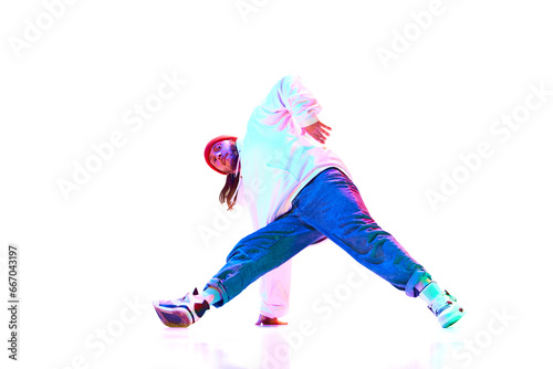 Young man in sportswear in motion, dancing breakdance isolated over white studio background in neon light. Concept of contemporary dance, street style, fashion, hobby, youth. Ad