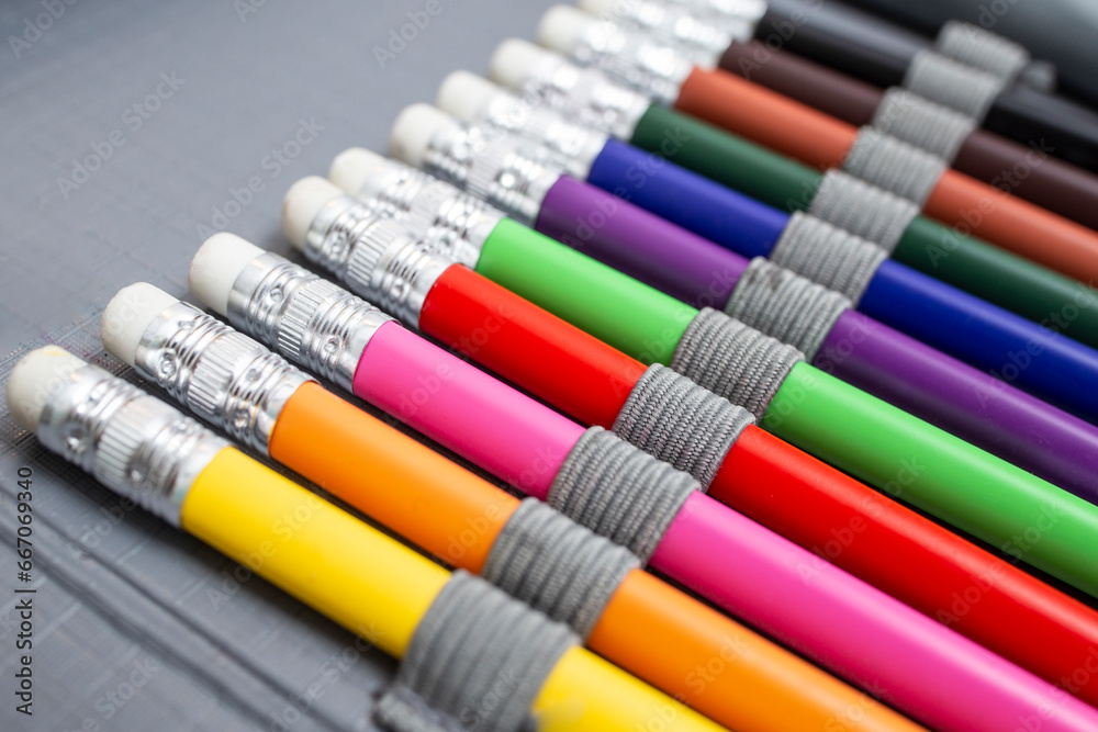 Rainbow colored pencil crayons with eraser, arranged in a pencil box, back to school abstract background, soft focus close up Rainbow colored pencil crayons with eraser, arranged in a pencil box, back to school abstract background, soft focus close up