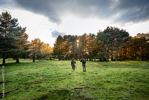 Hikers walk through a large meadow in the countryside in autumn. © Rafael Alejandro