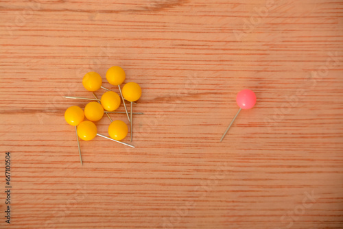 Among a group of yellow clothespins, the solitary pink one appeared to be abandoned and exceptional. photo