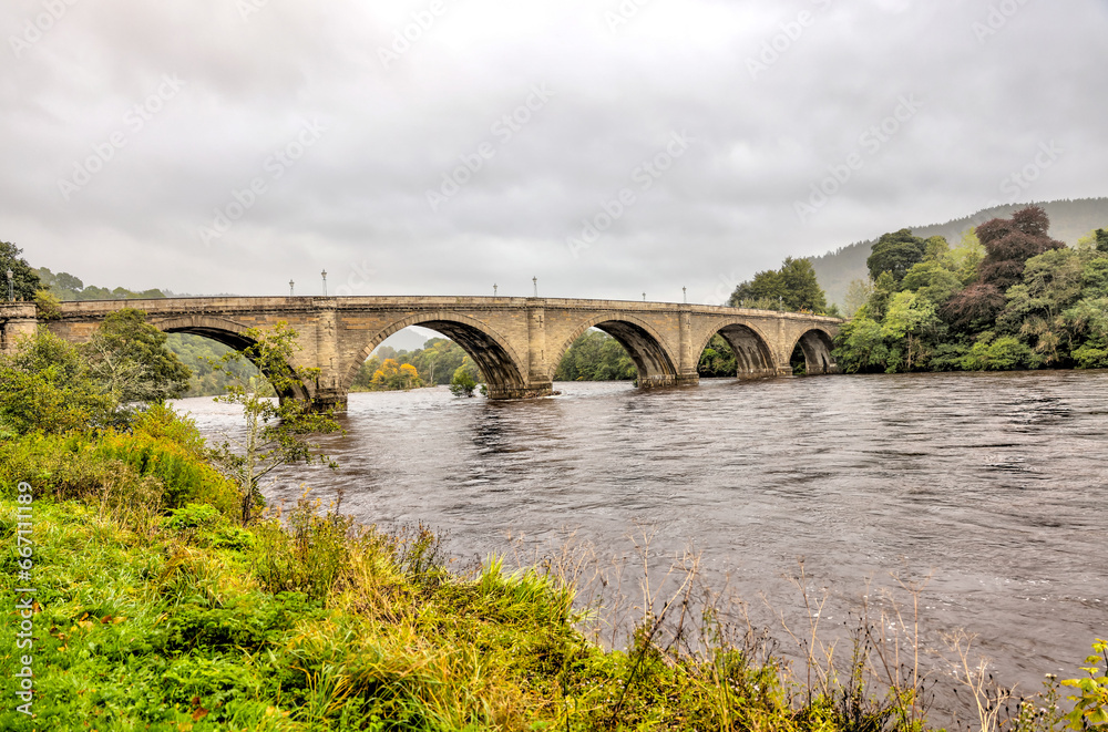 Dunkeld, Scotland - September 25, 2023: The ancient bridge over the Tay River in Dunkeld, Scotland

