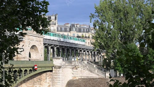 The parisian urban subway (MP 73 metro, metropolitain) passes over a bridge (pont de Bir-Hakeim Passy MP73 line 6) with Haussmann-style buildings in the background in the French capital, Paris, France photo