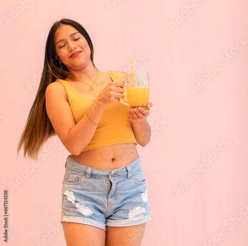 Bella y joven mujer sexy sosteniendo un jugo de naranja photo