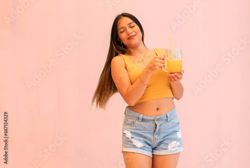Bella y joven mujer sexy sosteniendo un jugo de naranja. photo