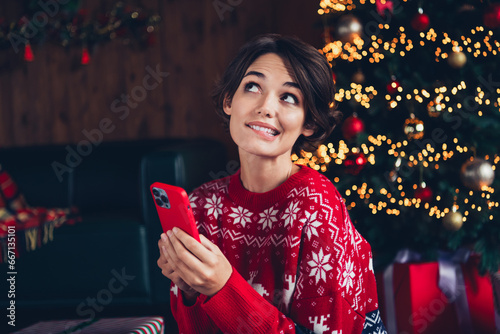 Photo of pretty young girl gadget look wondered empty space wear trendy red sweater festive interior living room presents christmas tree © deagreez