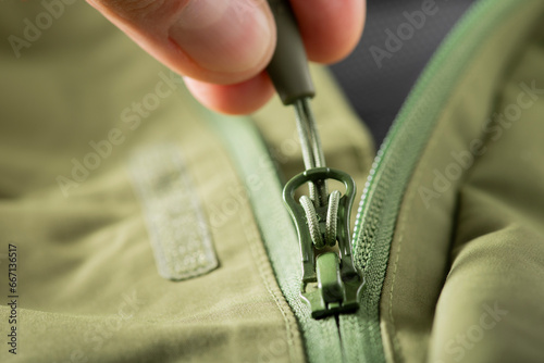 close-up zipper lock on green clothes.