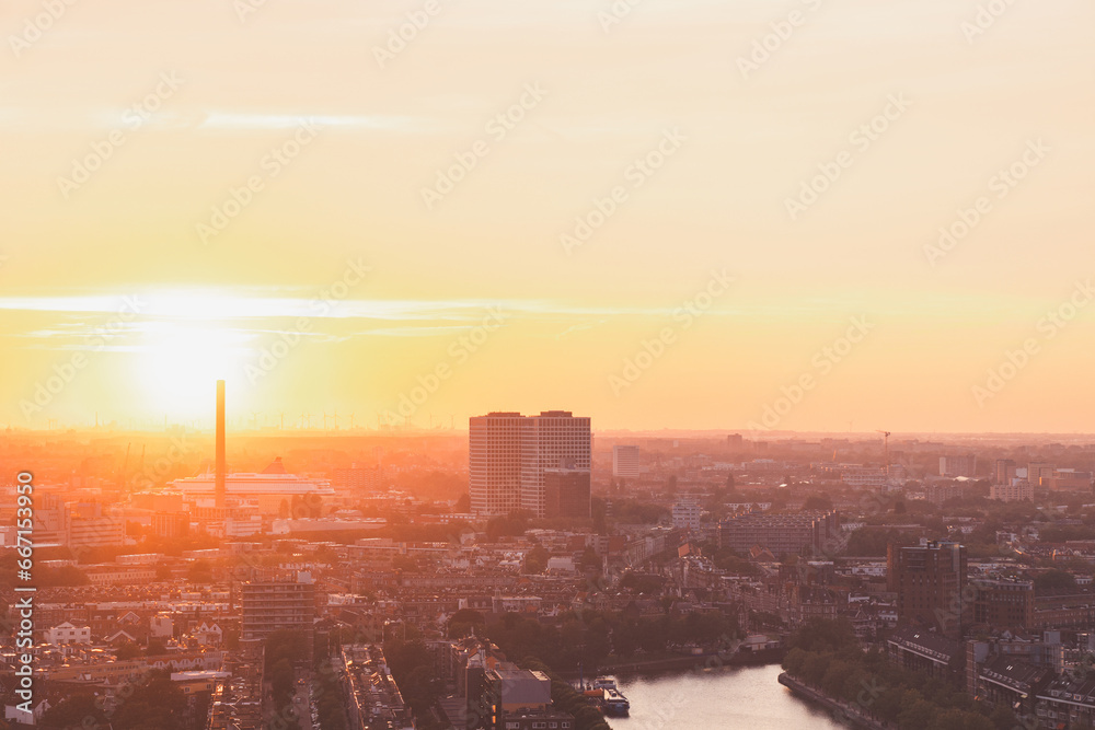 Fototapeta premium Sun setting over the horizon in Rotterdam. Red light irradiation of the wind farm and the harbour. Sunset in Netherlands