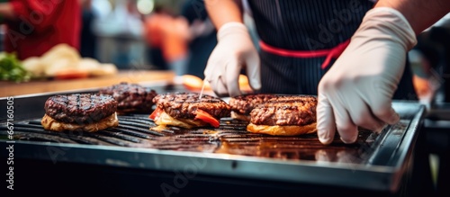Chef grilling burgers at an outdoor international food festival Street food served from stall