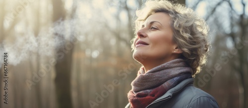 Contented middle aged woman enjoying winter forest air