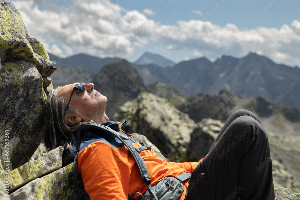 Close-up of man enjoying rest after climbing mountain peak, Austria