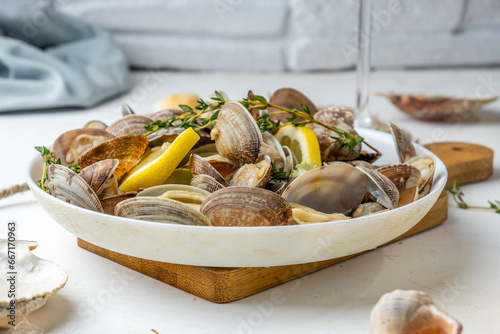 Vongole clams with lemon and herbs in a white plate