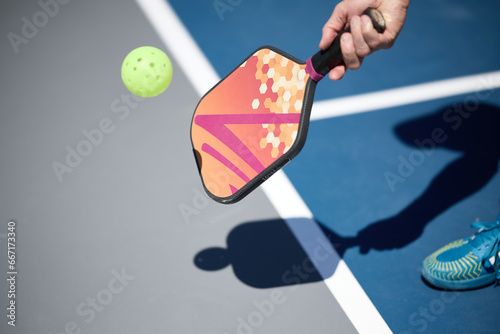 Hand holding a pickleball paddle