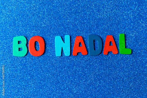 colored letters with the phrase Bo Nadal in Galician on a blue background with glitter, Christmas concept

 photo