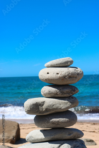 Zen stone little pile on sea beach. The stones of the pyramid balance on the rock. Zen stones balance spa on beach.