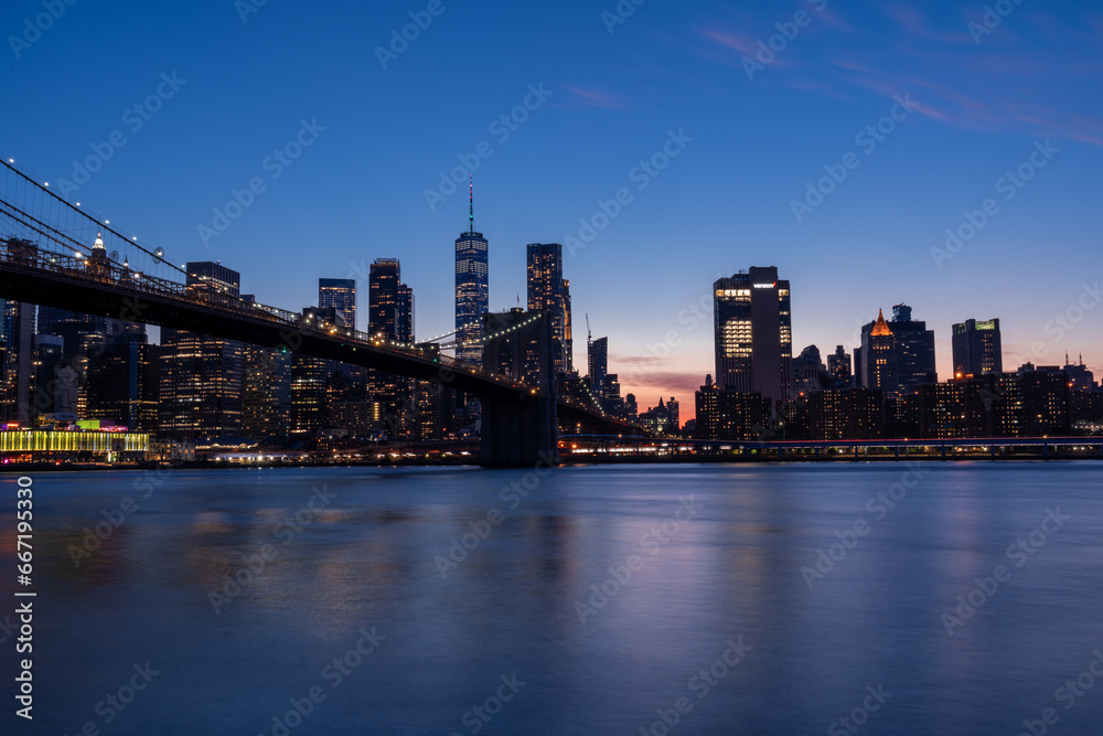 Photograph of Brooklyn Bridge, early evening, bluish light.