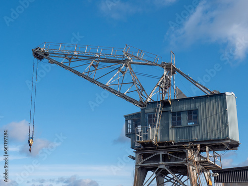 Old nostalgic port wooden crane against the blue sky