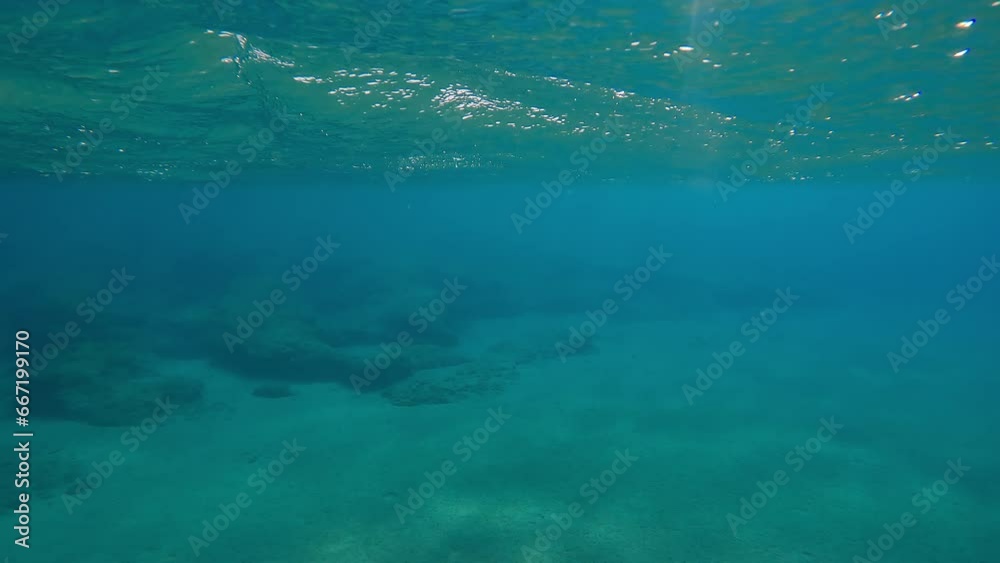 POV underwater shot, Close-up of male hands dives underwater and swims on blue water over rocky seabed on sunny day. First person view, man swims in Mediterranean Sea POV underwater shot, Close-up of male hands dives underwater and swims on blue water over rocky seabed on sunny day. First person view, man swims in Mediterranean Sea