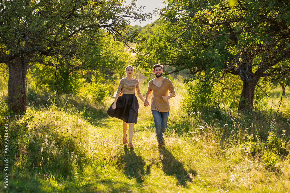 young couple walking in nature at sunset young couple walking in nature at sunset