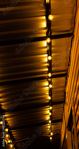 Garlands of yellow light bulbs in the night. Christmas mood