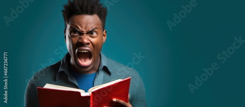 Furious young African American man reading with anger shouting and looking up photo