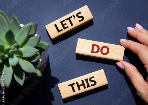 Lets do this symbol. Concept word Lets do this on wooden blocks. Businessman hand. Beautiful deep blue background with succulent plant. Business and Lets do this concept. Copy space