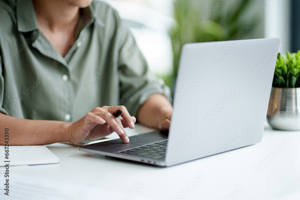 Businesswoman using laptop with technology to typing and working about calculation tax in office.. Businesswoman using laptop with technology to typing and working about calculation tax in office..
