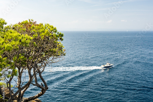 Schiff fährt auf blauem Meer an der Küste vorbei