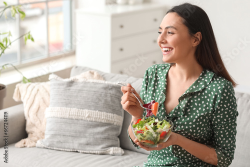 Young woman eating vegetabl...