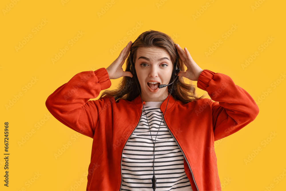 Shocked female technical support agent on yellow background Shocked female technical support agent on yellow background
