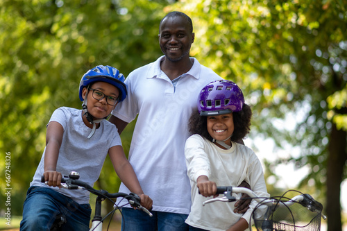 African american family having good time in a park and riding bikes