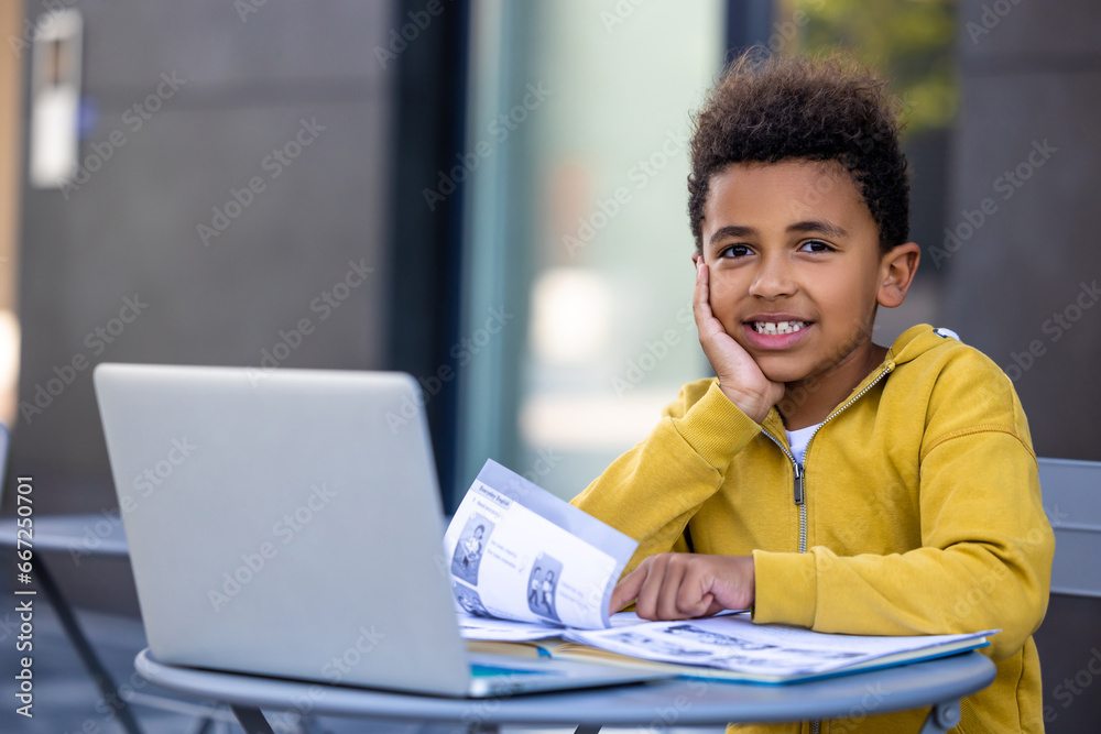Cute african american boy doing lessons and looking contented Cute african american boy doing lessons and looking contented