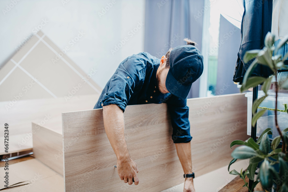 man assembling furniture wooden cabinet at home man assembling furniture wooden cabinet at home