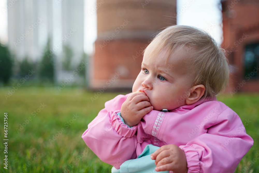 Blonde caucasian kid baby eats with her hands outdoor Blonde caucasian kid baby eats with her hands outdoor