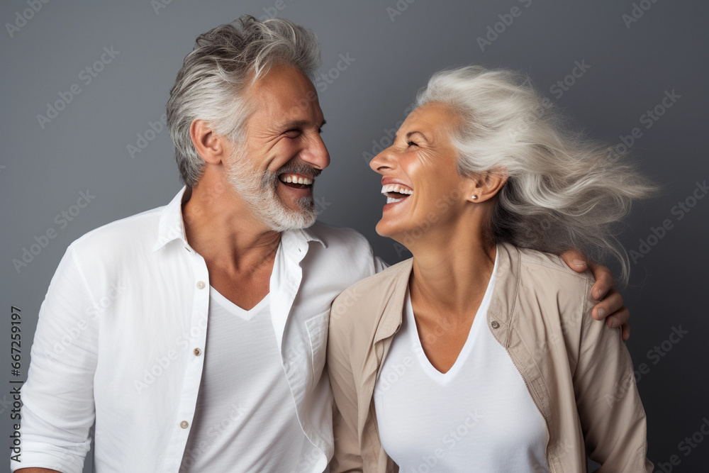 Studio shot of senior couple posing against a grey background Studio shot of senior couple posing against a grey background