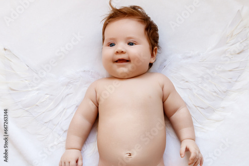 Beautiful Baby . Cute infant angel with wings isolated on white. lovely baby with wings of an angel on a white background. Happy angelic baby looking up