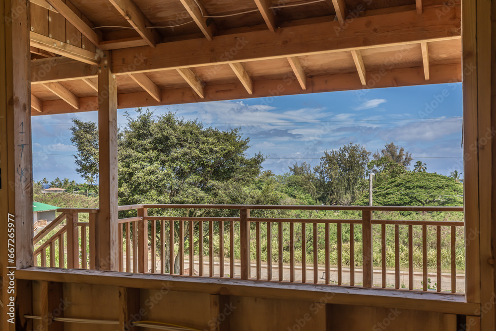 New Home construction with wood, view of deck railing and yard with trees