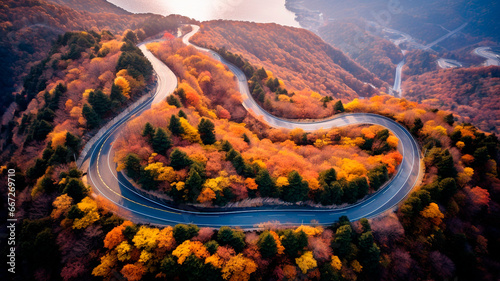 Aerial shot over a winding road on top of a mountain with fall trees, Generative AI © Yuriy Maslov