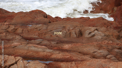 Hope concept. Painting of hope on the rocks at the beach.