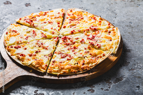 Traditional French dish tarte flambee with cream cheese, bacon and onions. Flammkuchen from Alsace region. photo