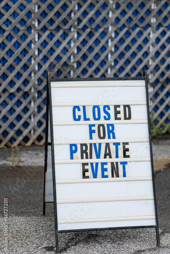 Closed for private event letter board sign, blue and black letters on white letter board at outdoor event photo