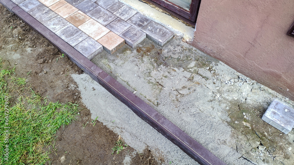 Close-up shot of a worker expertly laying paving stones during a renovation. Close-up shot of a worker expertly laying paving stones during a renovation.