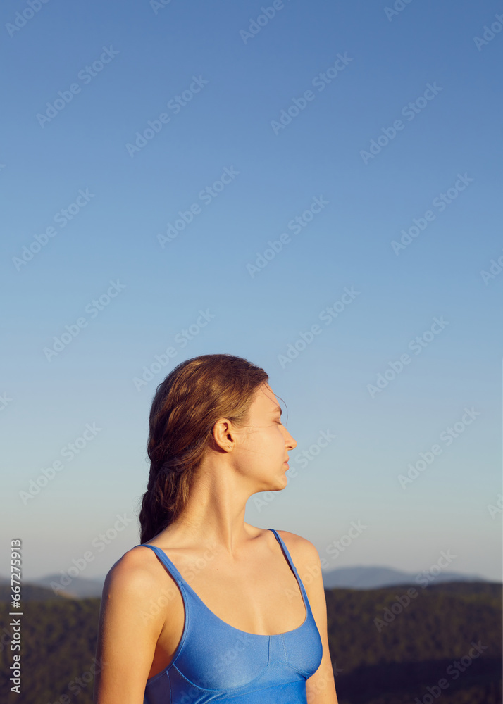 portrait of a beautiful carefree woman enjoying a vacation against the background of blue sky and mountains in the distance,