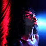 Close portrait of a naked young and beautiful woman experiencing orgasm in the style on red and blue neon lighting