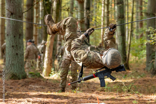 Unidentified Army soldiers training to cross a river tyrolean rope traverse. 
