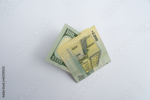 A 2,000 Uruguayan Pesos Banknote Next to a 100 US Dollar Bill, Comparing Currencies. Economic Concept.