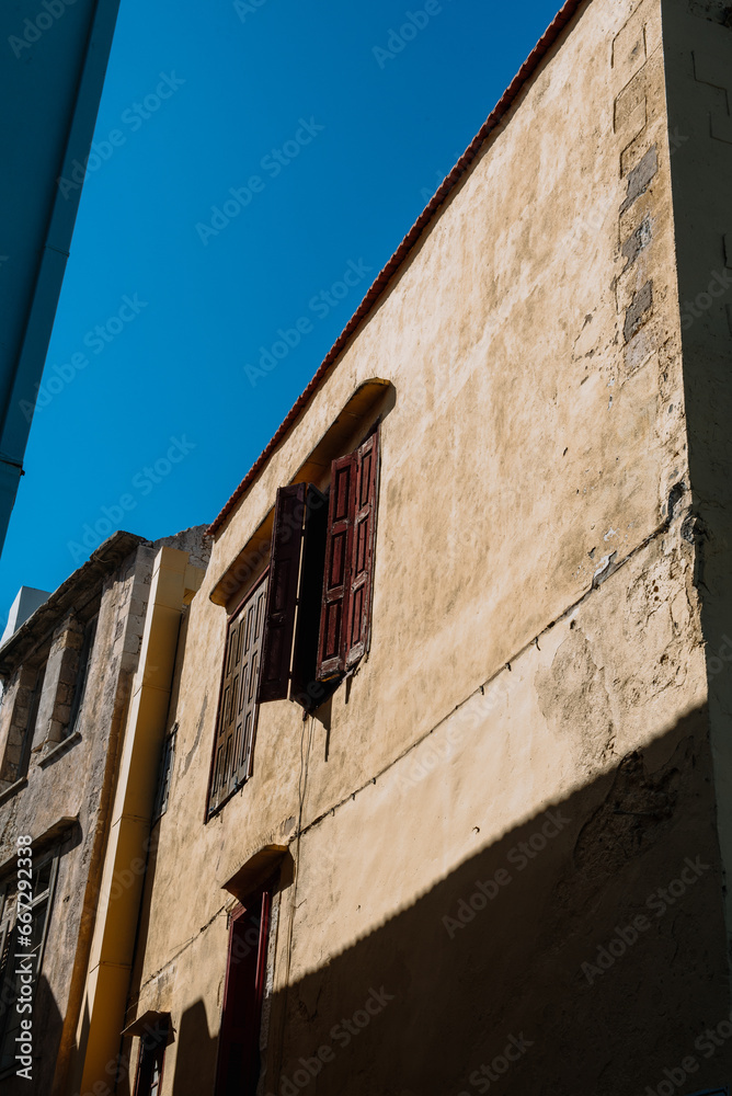 Mediterranean style urban building wooden jalousie in sunshine, blue sky
