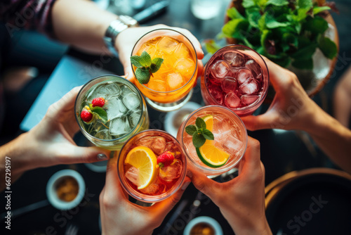Top-View Shot of friends toasting colorful cocktails on a vibrant terrace	
 photo