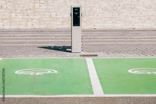 Electric car charger sign on ground near charger station photo