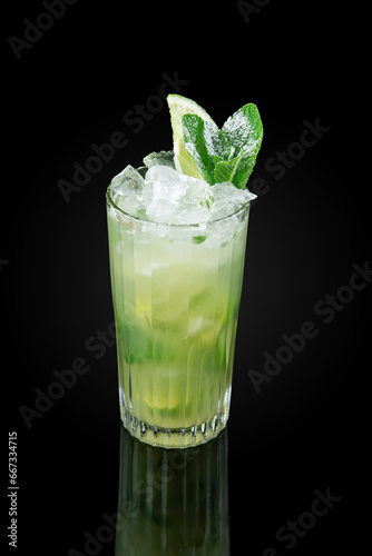 The Mojito. Alcoholic cocktail based on light rum and mint leaves. Glass on dark background with reflection