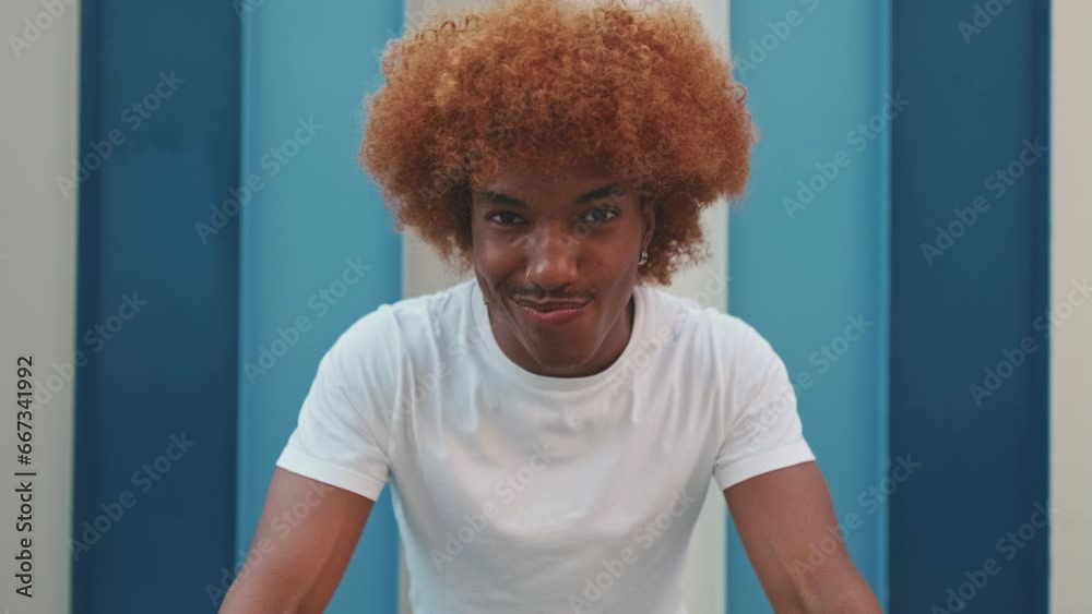 Young smiling man looking at camera on striped wall background Young smiling man looking at camera on striped wall background